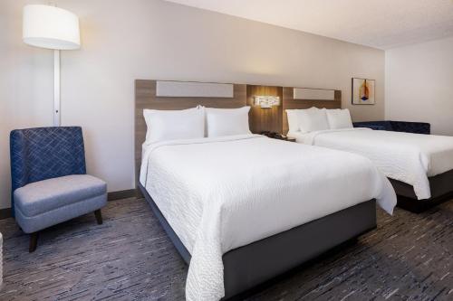 a hotel room with two beds and a chair at Holiday Inn Express and Suites Tampa I-75 at Bruce B. Downs by IHG in Tampa