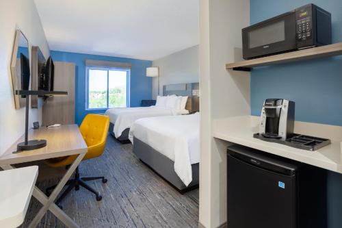 a hotel room with two beds and a desk at Holiday Inn Express and Suites Tampa I-75 at Bruce B. Downs by IHG in Tampa