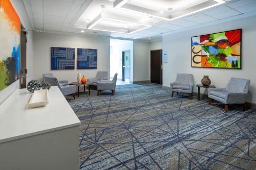 a waiting room with chairs and a painting on the wall at Holiday Inn Express and Suites Tampa I-75 at Bruce B. Downs by IHG in Tampa