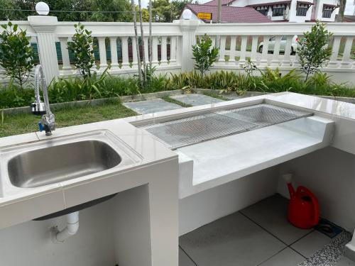 a kitchen with a sink in a white counter top at Yes Muar in Muar