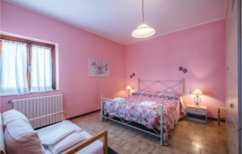 モンタイオーネにあるVin Santoのピンクの壁のベッドルーム1室、ベッド1台、ソファが備わります。