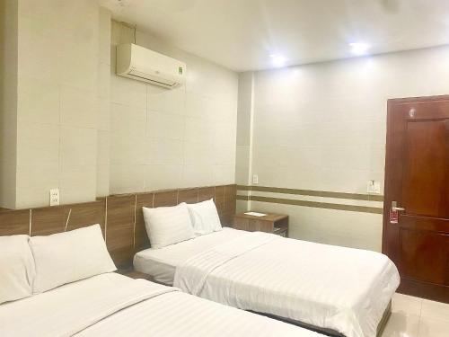 a hotel room with two beds with white sheets at Shine Hotel in Hue