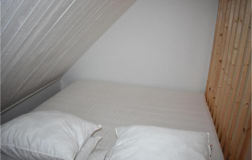 a white bed with two pillows in a room at Beautiful Home In stra Snnarslv With 1 Bedrooms And Wifi in Östra Sönnarslöv