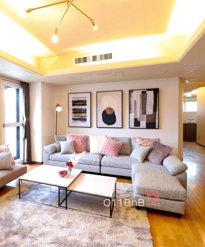 a living room with a couch and a coffee table at NK BLD7F Sapporo 3LDK 3BR 1 floor 1 room in Sapporo