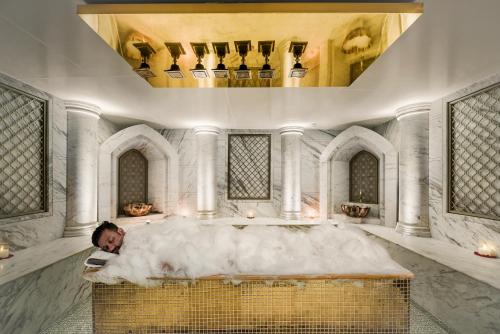 a man laying in a bath tub in a room at Radisson Blu Hotel & Suites GRT Chennai in Chennai
