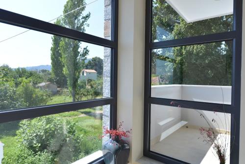a room with three windows with a view at Villa Aggemari in Apidias Lakos
