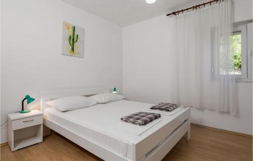 a white bedroom with a white bed and a window at Nice Apartment In Senj With 2 Bedrooms And Wifi in Senj