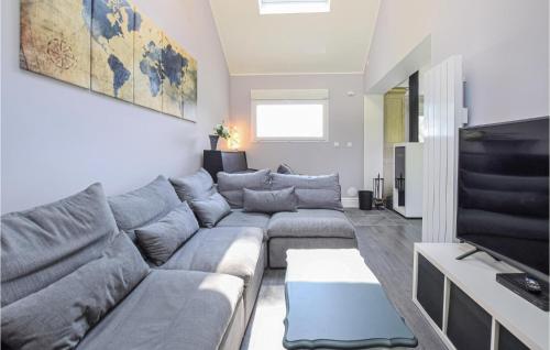 a living room with a couch and a tv at Gorgeous Home In St-Martin-Aux-Buneaux in Saint-Martin-aux-Buneaux
