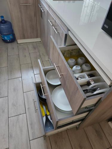 a kitchen drawer with plates and utensils in it at Departamento Interior 026 2do Piso, Quilicura in Santiago