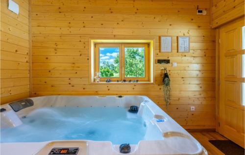 uma grande banheira num quarto de madeira com uma janela em Cozy Home In Buzim With Sauna em Bužim