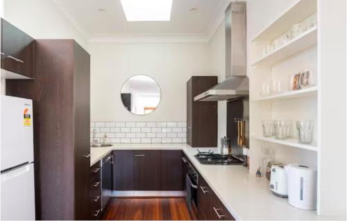 a kitchen with brown cabinets and a white counter top at Manly Sunset Lagoon in Sydney