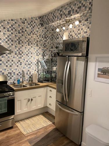 a kitchen with a stainless steel refrigerator and a sink at Hawaii Getaway in Holualoa