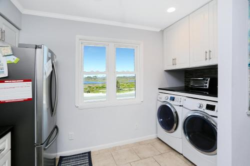 a kitchen with a refrigerator and a washer and dryer at Pelican Crossing by Pristine Properties Vacation Rentals in Cape San Blas