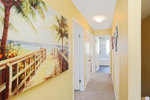 a hallway with a painting of the beach and palm trees at Pelican Crossing by Pristine Properties Vacation Rentals in Cape San Blas