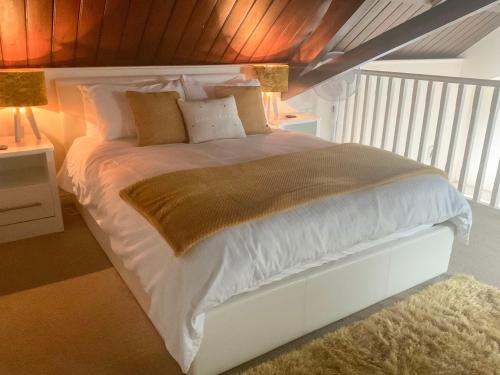 a bedroom with a large white bed with two lamps at Robins Nest in Edwinstowe