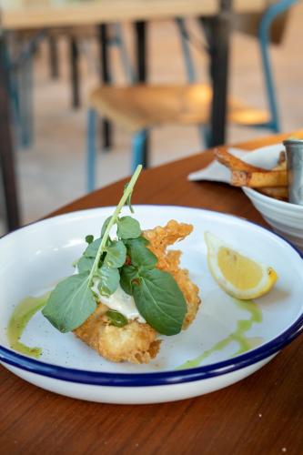 une plaque blanche avec un morceau de nourriture sur une table dans l'établissement Grande maison à deux pas de la mer, à Bray-Dunes