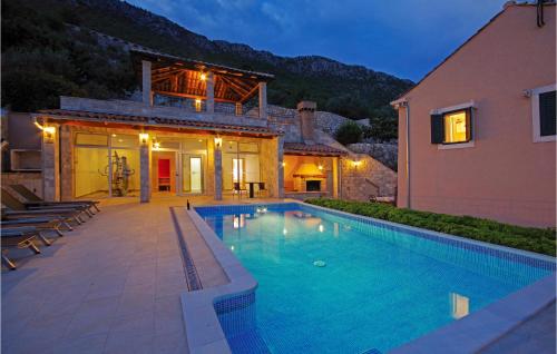 a swimming pool in front of a house at Beautiful Home In Trsteno With Wifi in Trsteno