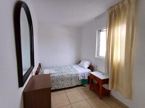 Habitación pequeña con cama y ventana en Urban House, en Lima