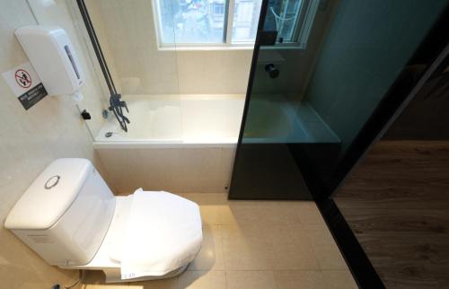 a bathroom with a white toilet and a shower at Puremeworld Hotel in Taipei