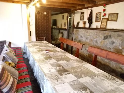 una habitación con 2 mesas y un banco en una habitación en Къща за гости Старата череша село Раждавица en Rzhdavitsa