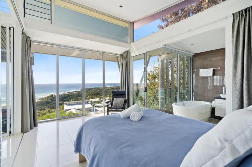 a bedroom with a blue bed and a view of the ocean at Allure in Point Lookout
