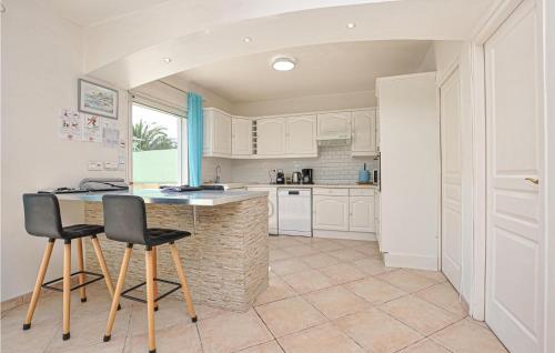 une cuisine avec des armoires blanches et une table et des chaises dans l'établissement Lovely Home In Saint Raphael, à Saint-Raphaël