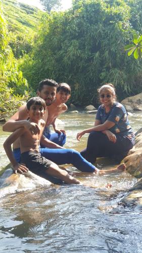 a group of people sitting on rocks in a river at LAZY DAYS Wayanad in Cherambādi