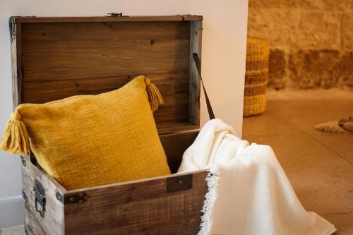 a wooden box with a yellow pillow in it at Casetta Zio Franco in Polignano a Mare