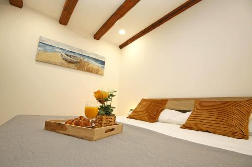 a bedroom with a bed with a wooden tray with a glass of orange juice at Apartment Tonka in Šibenik