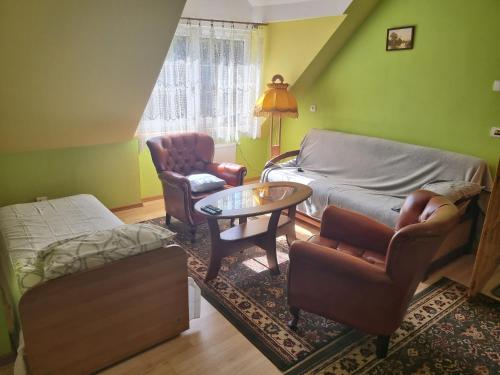 uma sala de estar com uma cama, uma mesa e cadeiras em Domek nad rzeką em Joniec