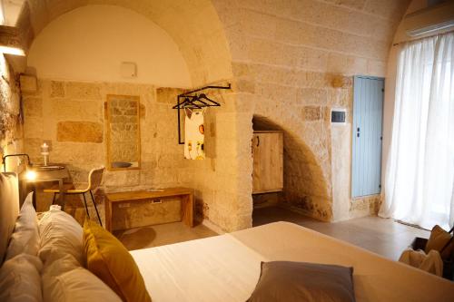 a bedroom with a bed in a stone wall at Casetta Zio Franco in Polignano a Mare