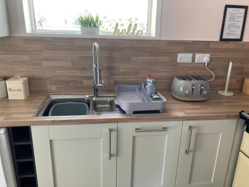 a kitchen counter top with a sink and a sink at Pebble Lodge in Paignton