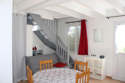 une chambre avec un escalier, une table et des chaises dans l'établissement Agréable maison de vacances, à Gallargues-le-Montueux