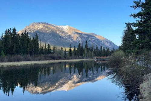 a mountain reflection in a river with a mountain at unit #303 Mountain view 1BR in Canmore DownTown in Canmore