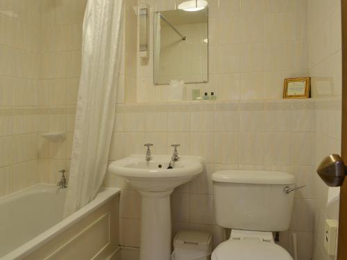 uma casa de banho com um lavatório, um WC e uma banheira em Grooms Room em Thirlmere