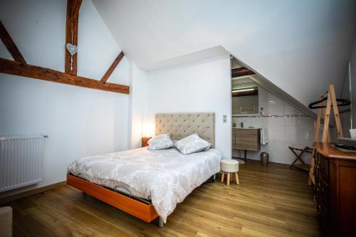 ein Schlafzimmer mit einem großen Bett und einer Treppe in der Unterkunft Gîte Chez Louis le Tonnelier Suite Edouard in Le Mesnil-sur-Oger