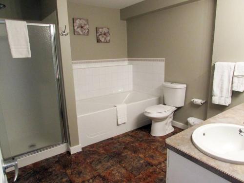 a bathroom with a tub and a toilet and a sink at Paradise Canyon Golf Resort, Signature Walkout Condo 382 in Lethbridge