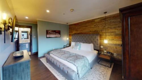 韋爾的住宿－Slopeside 1 Bedroom Platinum-rated Residence At Golden Peak，一间卧室设有一张大床和木墙
