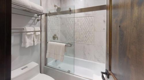 韋爾的住宿－Slopeside 1 Bedroom Platinum-rated Residence At Golden Peak，带淋浴的浴室以及带玻璃门的卫生间。