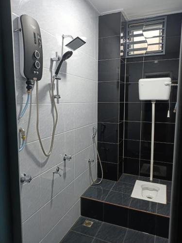 a bathroom with a shower and a phone on the wall at RIANI HOMESTAY in Kertih