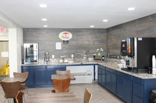 uma cozinha com armários azuis e um balcão com cadeiras em Baymont by Wyndham Morganton em Morganton
