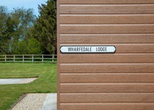 a sign on the side of a building with a wildlife lodge at Cleveland Hills View Holiday Park in Middleton upon Leven
