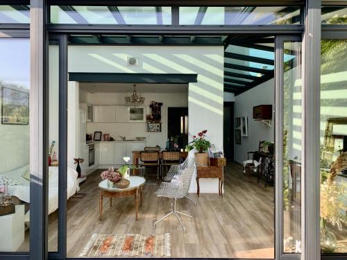 a living room and dining room with a glass extension at LA MAISON d'HORTENSE, maison de charme et de caractère in Toulouse