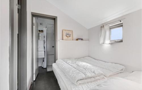 a white bedroom with a bed and a window at Stunning Apartment In Nrre Nebel With Sauna, Wifi And 2 Bedrooms in Nørre Nebel