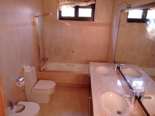 a bathroom with a sink and a toilet and a tub at A Lúa do Camiño in Melide