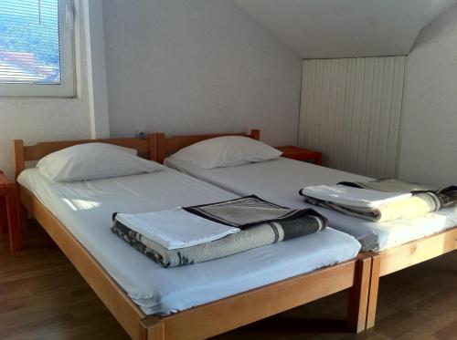 a bedroom with two beds with towels on them at Guest House Lokoski in Peštani