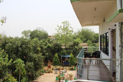 a balcony with a view of a garden at "Priyadarshi Villa" Free pickup in ac car from Jasidih Railway station or Deoghar Airport in Deoghar