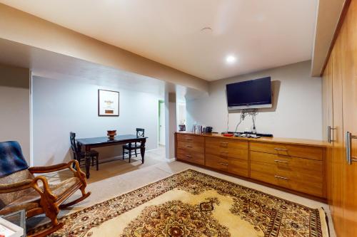 a living room with a tv and a chair and a table at Crown Mountain Retreat in Carbondale
