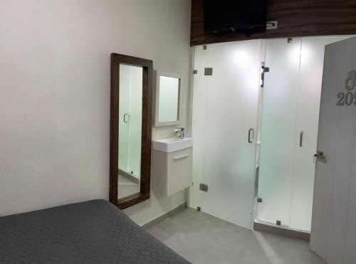 uma casa de banho com um lavatório, um espelho e uma cama em Bed Bed Hotel Abasolo em Torreón