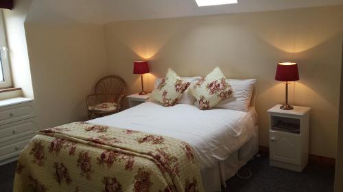 a bedroom with a bed with pillows and two lamps at Coulagh Bay House in Eyeries